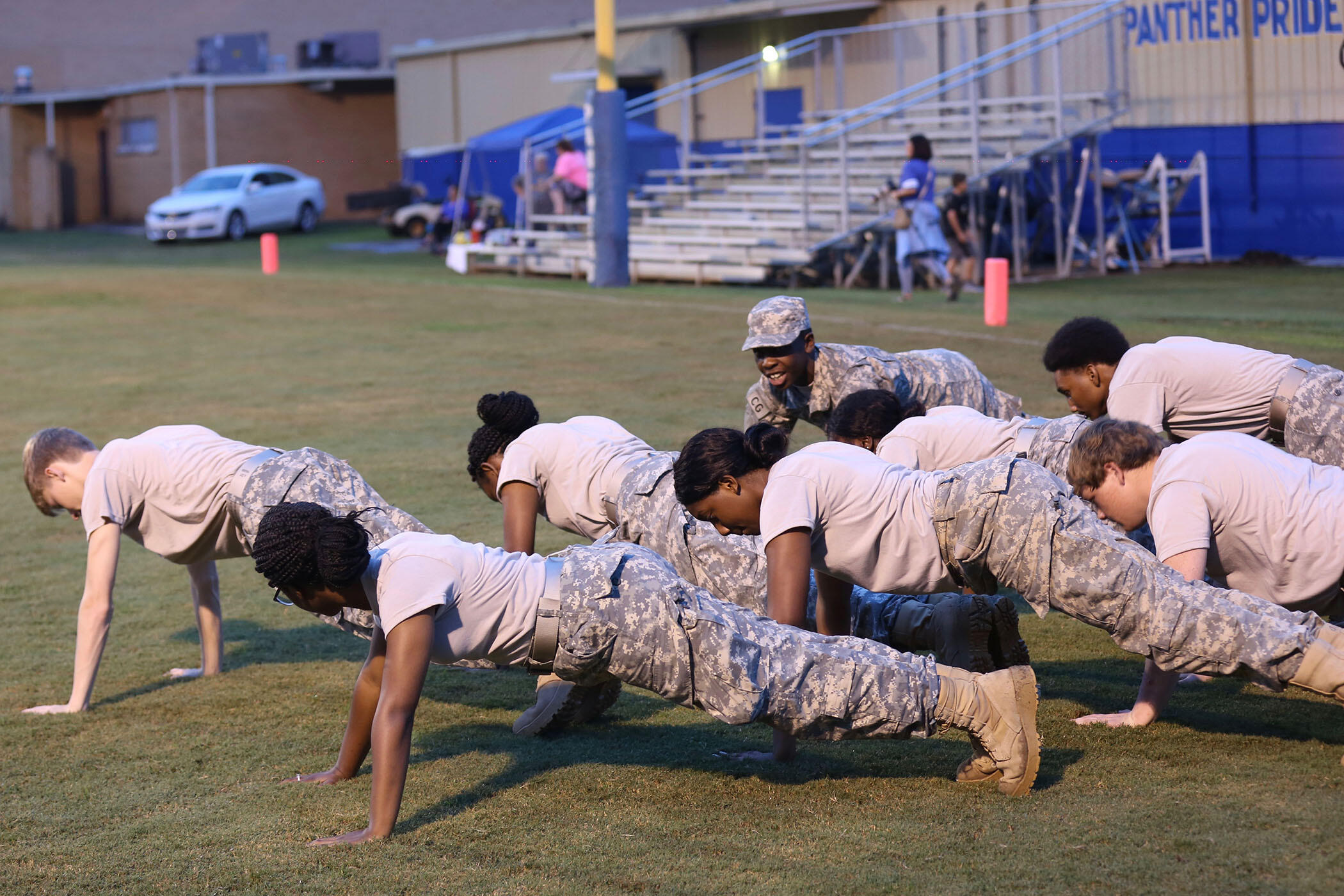 Panther JROTC do pushups on Panther Field after a touchdown.